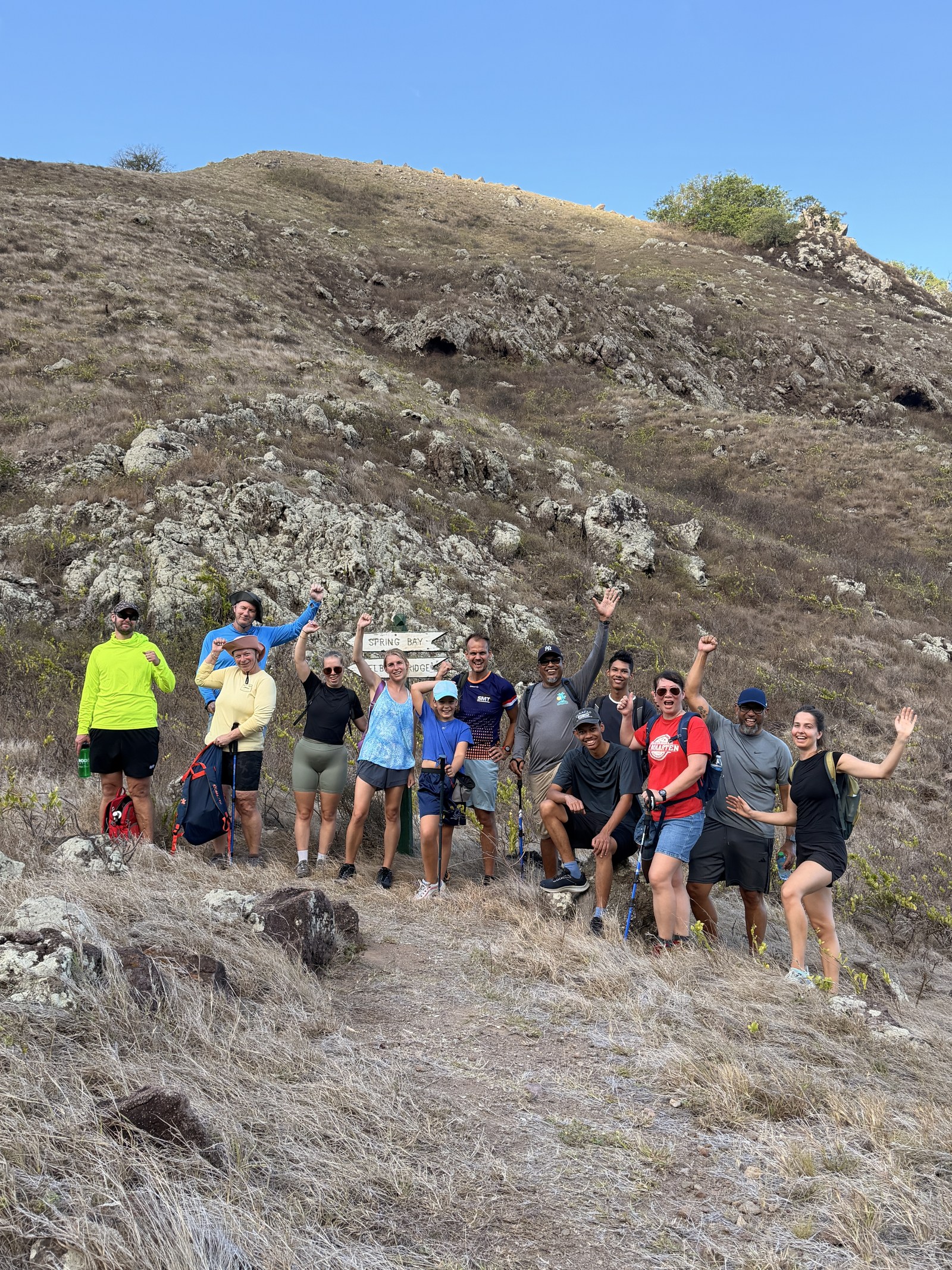 A group of hikers on the ridge, arms up